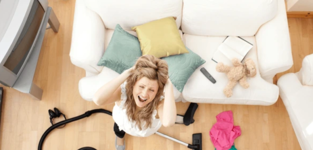 Image if woman screaming in despair in the living room, while cleaning